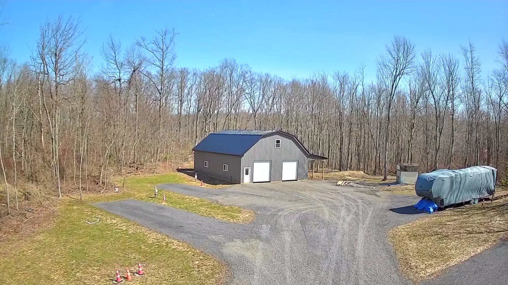 Aerial view of completed barndominium with driveway approach